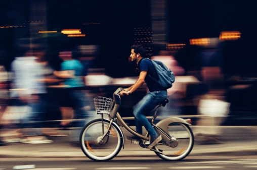 Middle aged man on an electronic bike riding through a city | Post Holiday Diets Don’t Work! | e-Surgery