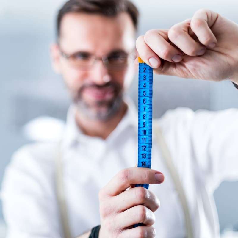 man holding a tape measure. 5 reasons why being vertically challenged is good for your health | e-Surgery