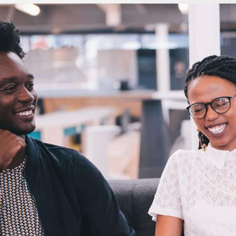 The new 9-5, three people sitting on an office sofa talking and smiling | e-Surgery
