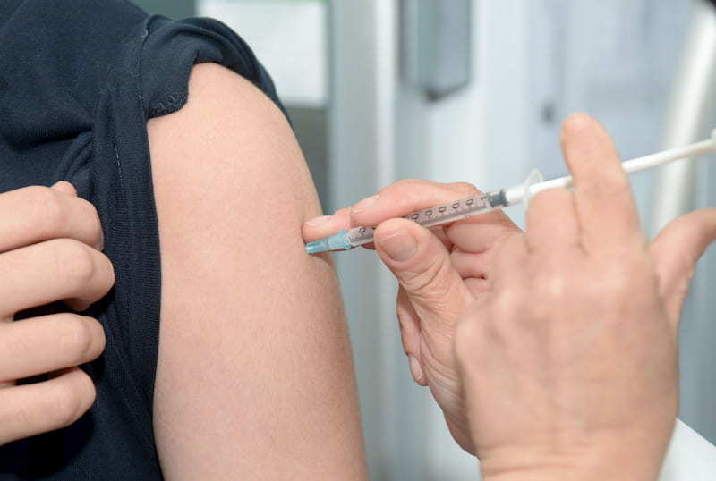 Male with a black t-shirt on getting an injection from a doctor in a white lab coat | The Male Pill: Myth Or The Future Of Contraception? | e-Surgery