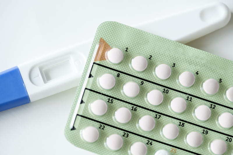 A green packet of combined pills resting on top of an unused pregnancy test | The (almost) A-Z of Contraception | e-Surgery