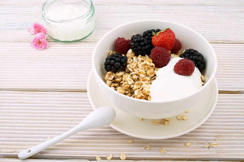 Bowl of granola and fruit on a wooden table | Trust Your Gut: Can Healthy Bacteria Make You Happy? | e-Surgery