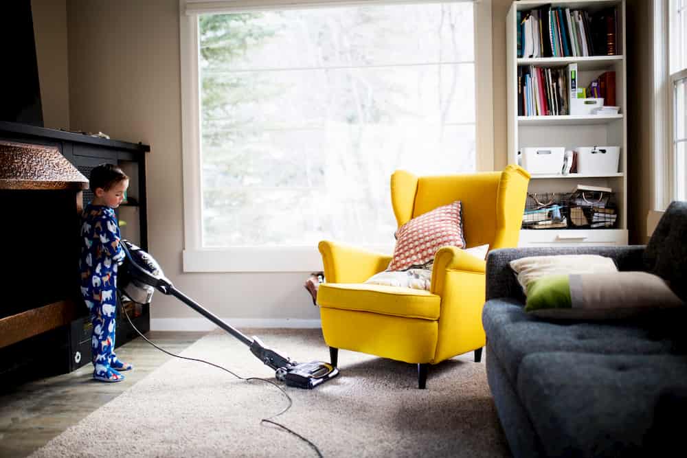 Person hoovering a living room, e-Surgery