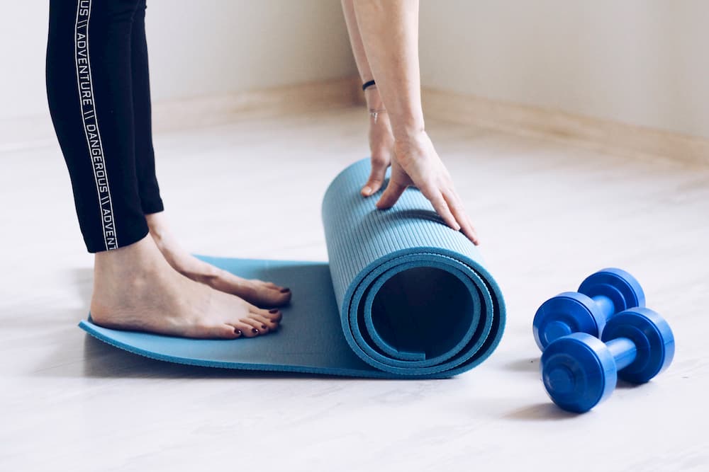 Person rolling yoga mat, e-Surgery