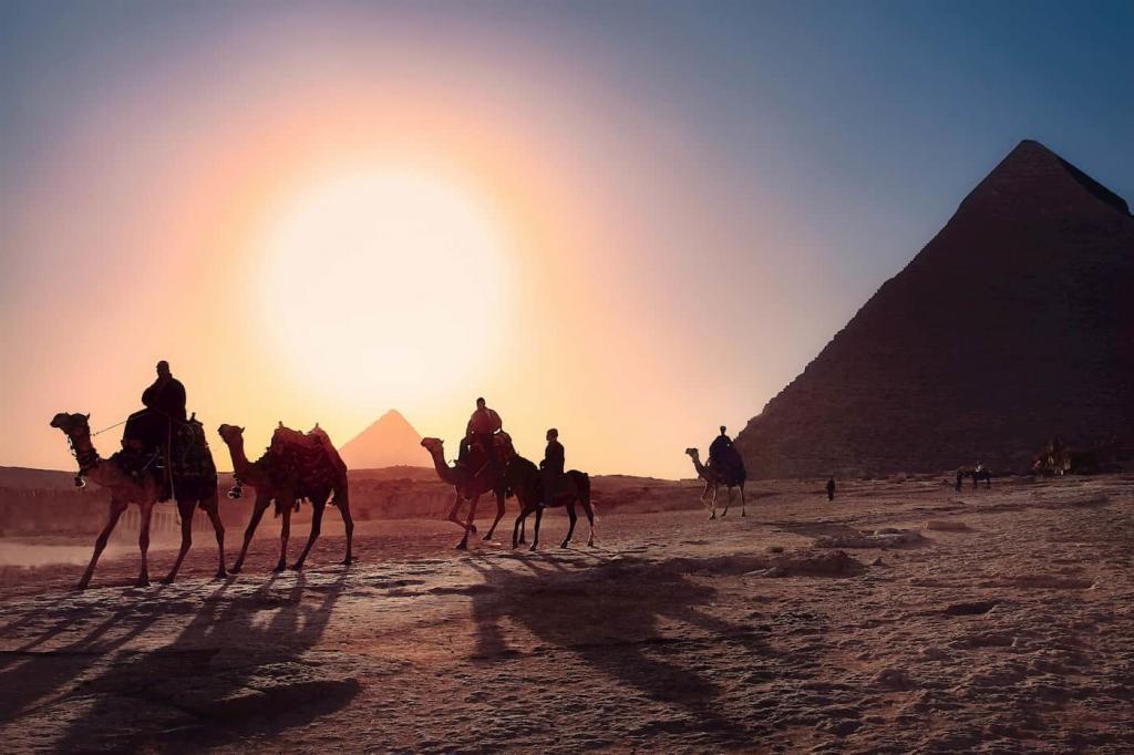 A sun is setting in a desert, there is a pyramid is in the background and six people are riding camels along a desert path | Period-tech: 5 Ways Technology is Changing Women’s Health | e-Surgery