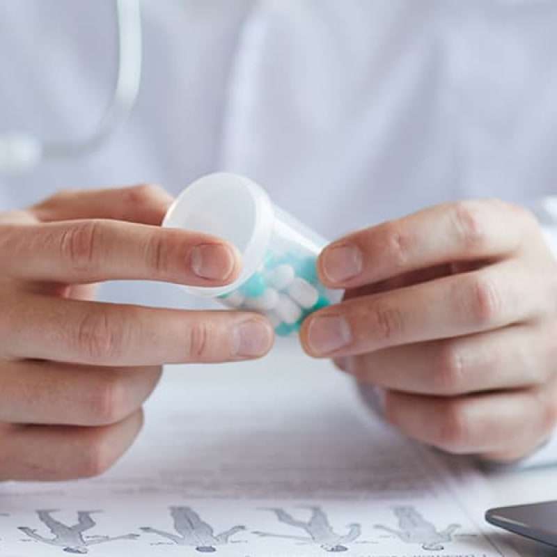 The truth about generic Viagra, doctor in white lab coat holding a pot of pills | e-Surgery