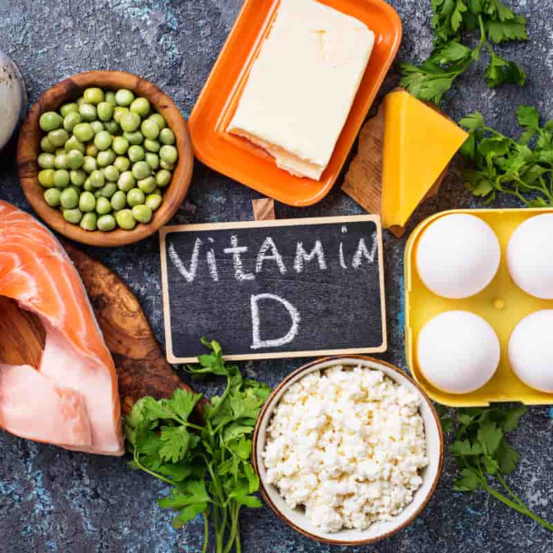 Header Image Vitamin D in Winter: Alternative Sources of Vit D When the Sun isn't Shining. Salmon, mushrooms, beans and cheese surrounding a chalkboard with 'vitamin D' written on it | e-Surgery