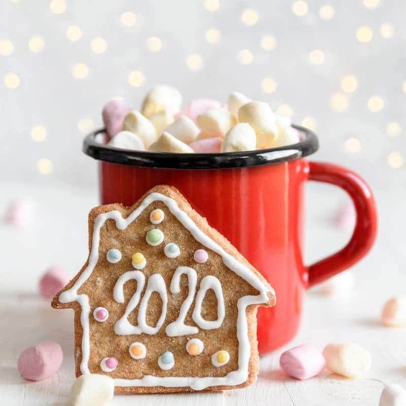 gingerbread biscuit that has 2020 on it in front of a red mug of hot chocolate | e-Surgery
