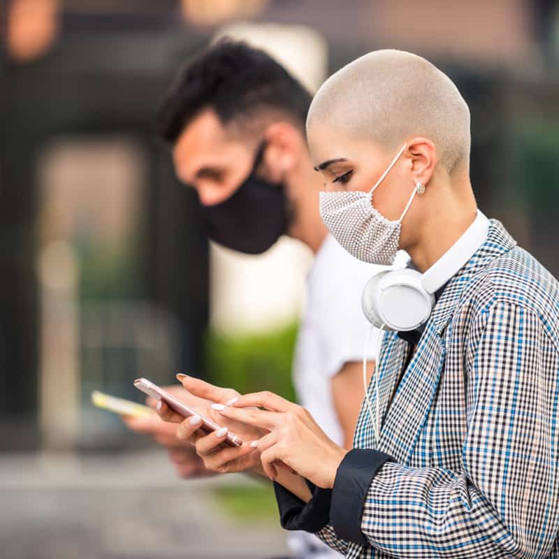 people looking at their phones with masks on. 5 things you need to know about Coronavirus | e-Surgery