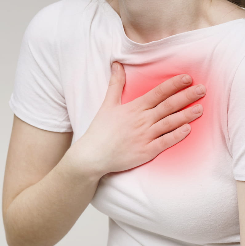 Woman holding chest suffering from acid reflux | e-Surgery
