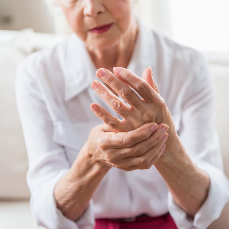 woman with arthritis holds hand in pain | e-surgery