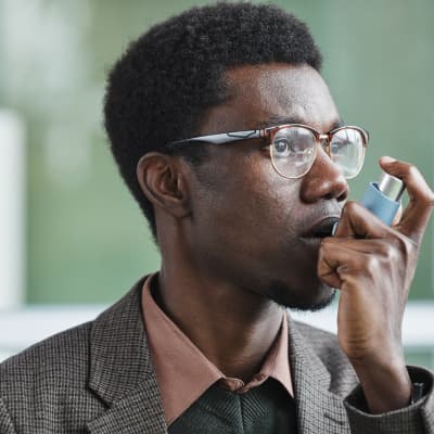 young man using inhaler to relive asthma | Qvar Inhaler | e-surgery