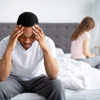 man sat on edge of bed feeling upset due to erectile dysfunction | e-surgery