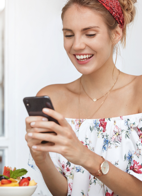 Woman holding mobile phone ordering treatment online | How it works | e-Surgery