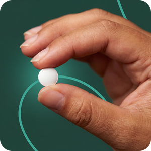 Hand holding pill in green background